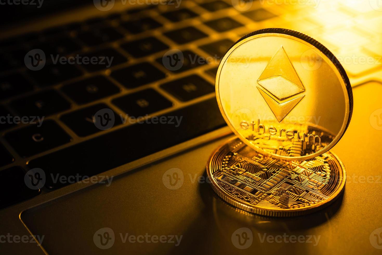 monedas de oro con símbolo de ethereum en la computadora. foto