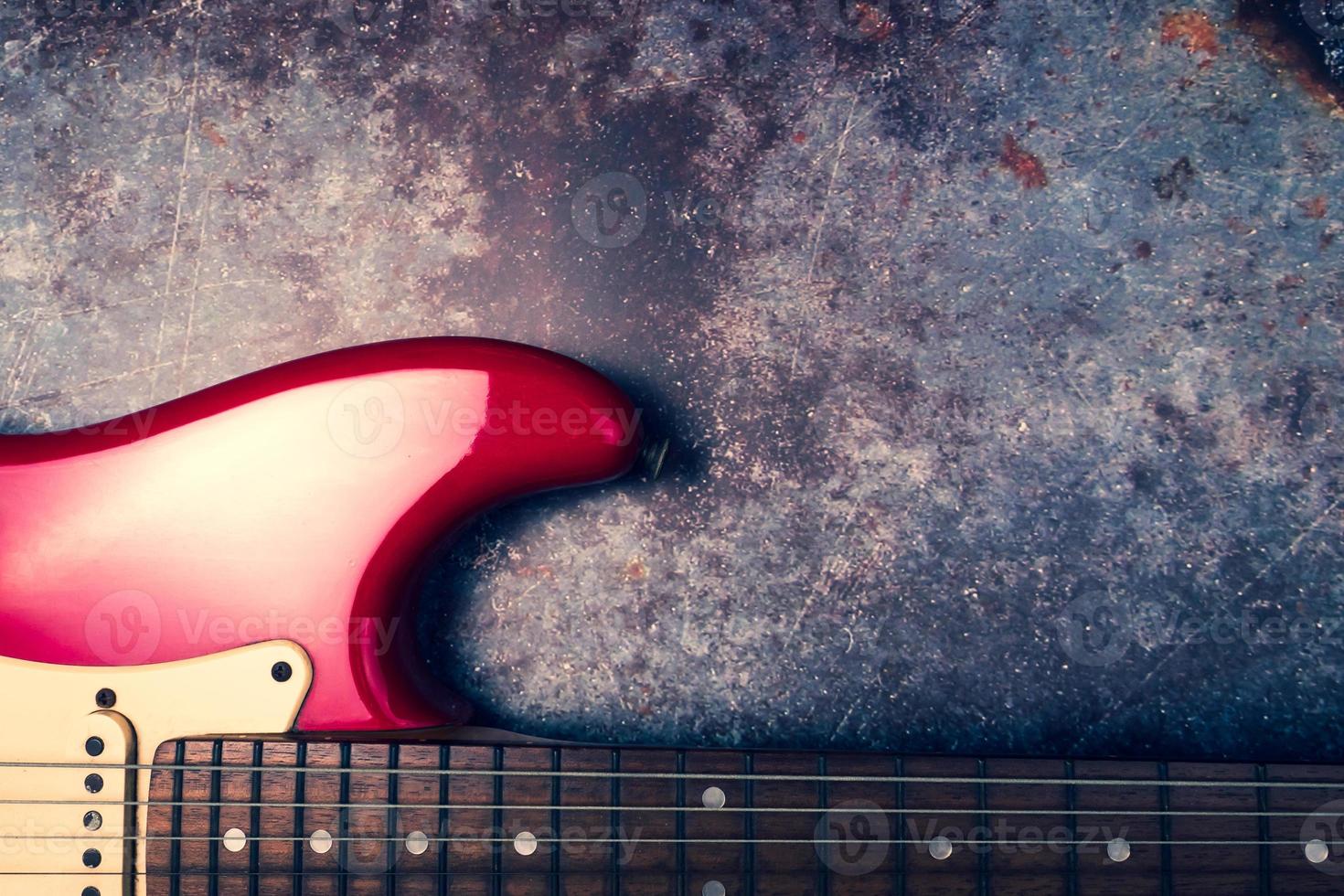 A red electric guitar on a grunge background. photo