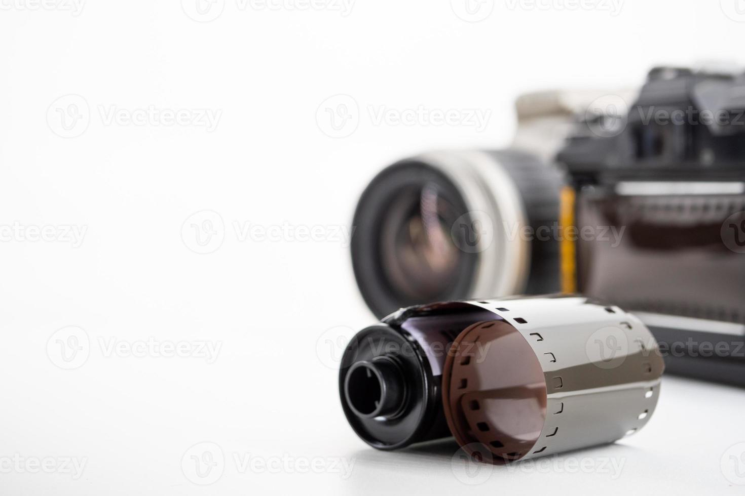 Single lens reflex cameras and film rolls on a white background. photo