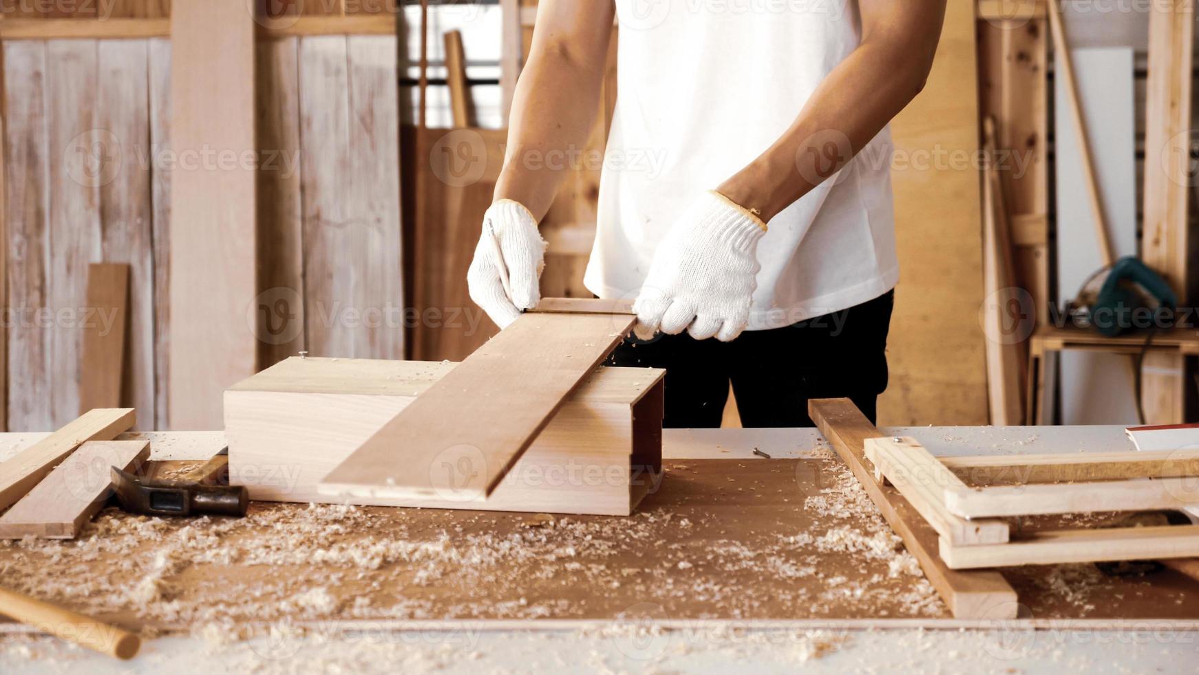 Carpenter holding pieces of board at site. photo