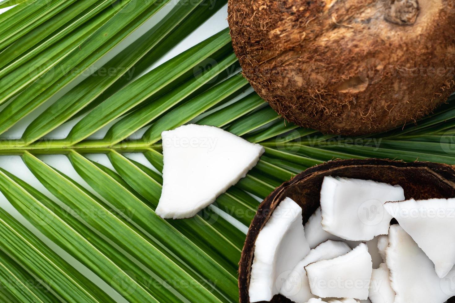 Coconut meat and coconut leaf on white table. photo