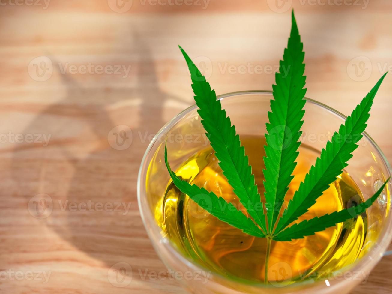 un vaso de té de marihuana caliente en la mesa madera. té de hierbas de cannabis con hoja verde. 9325804 Foto de stock en Vecteezy