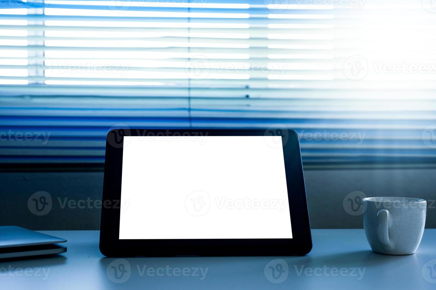 Blank screen tablet computer and a cup of coffee on the table photo