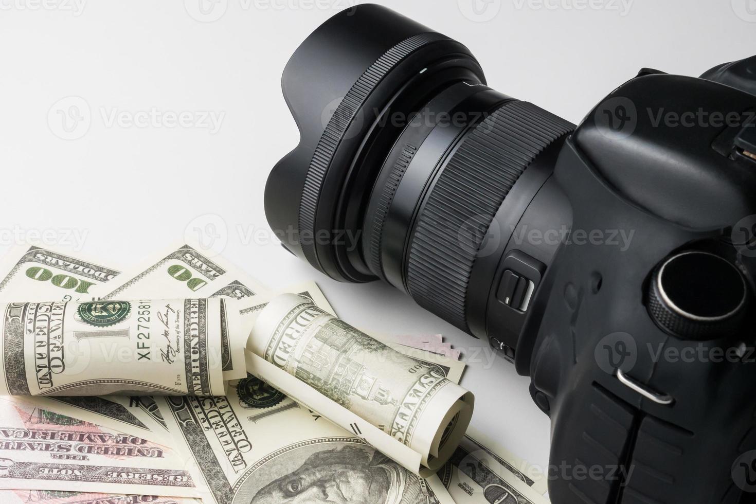 una cámara digital negra en billetes con fondo blanco. foto