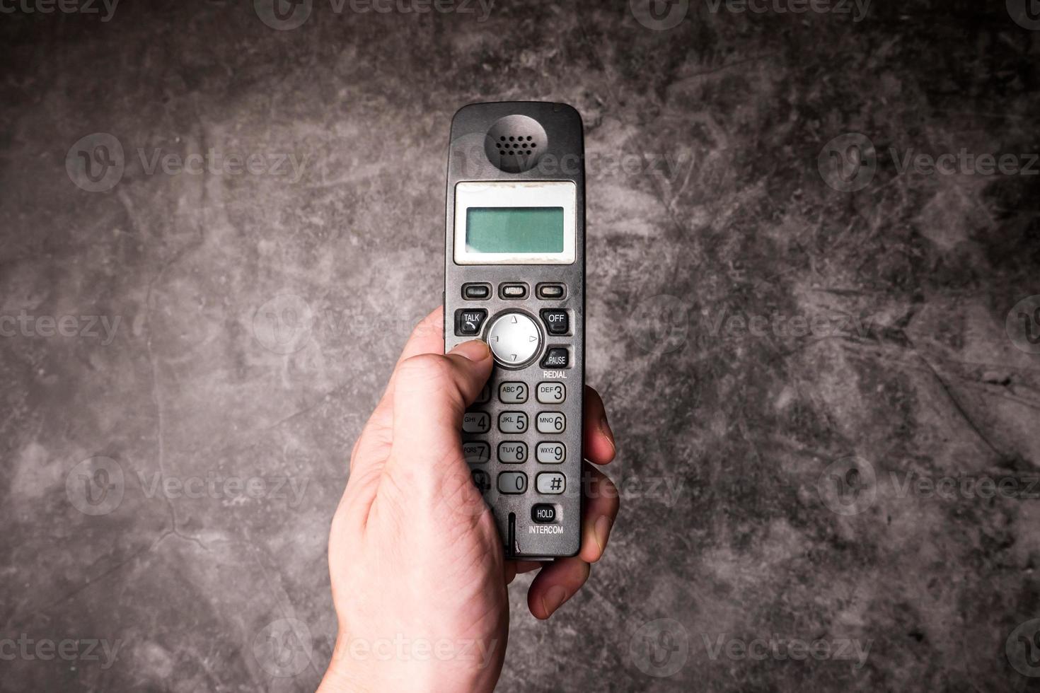 Close up of male hand press on button of an obsolete cellphone. photo