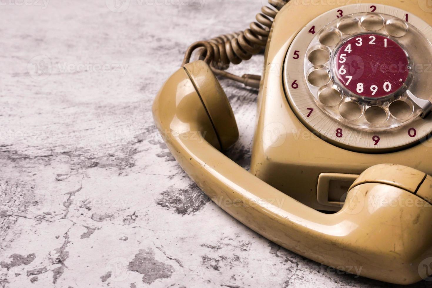 An old telephone with rotary dial on a grunge background. photo