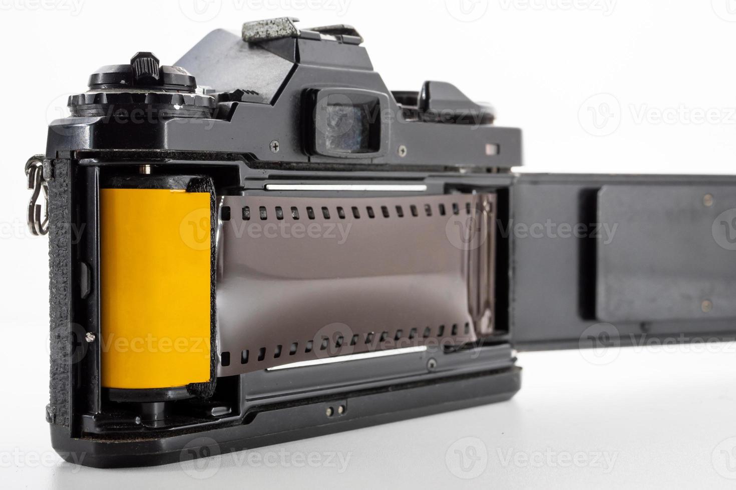 Single lens reflex camera and a film roll on a white background. photo