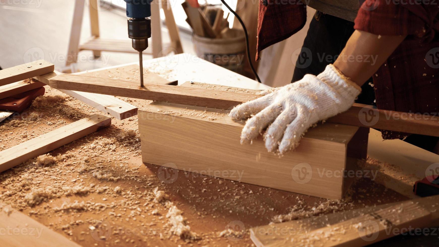 carpintero usando taladro para atornillar piezas de tablero en el sitio. foto
