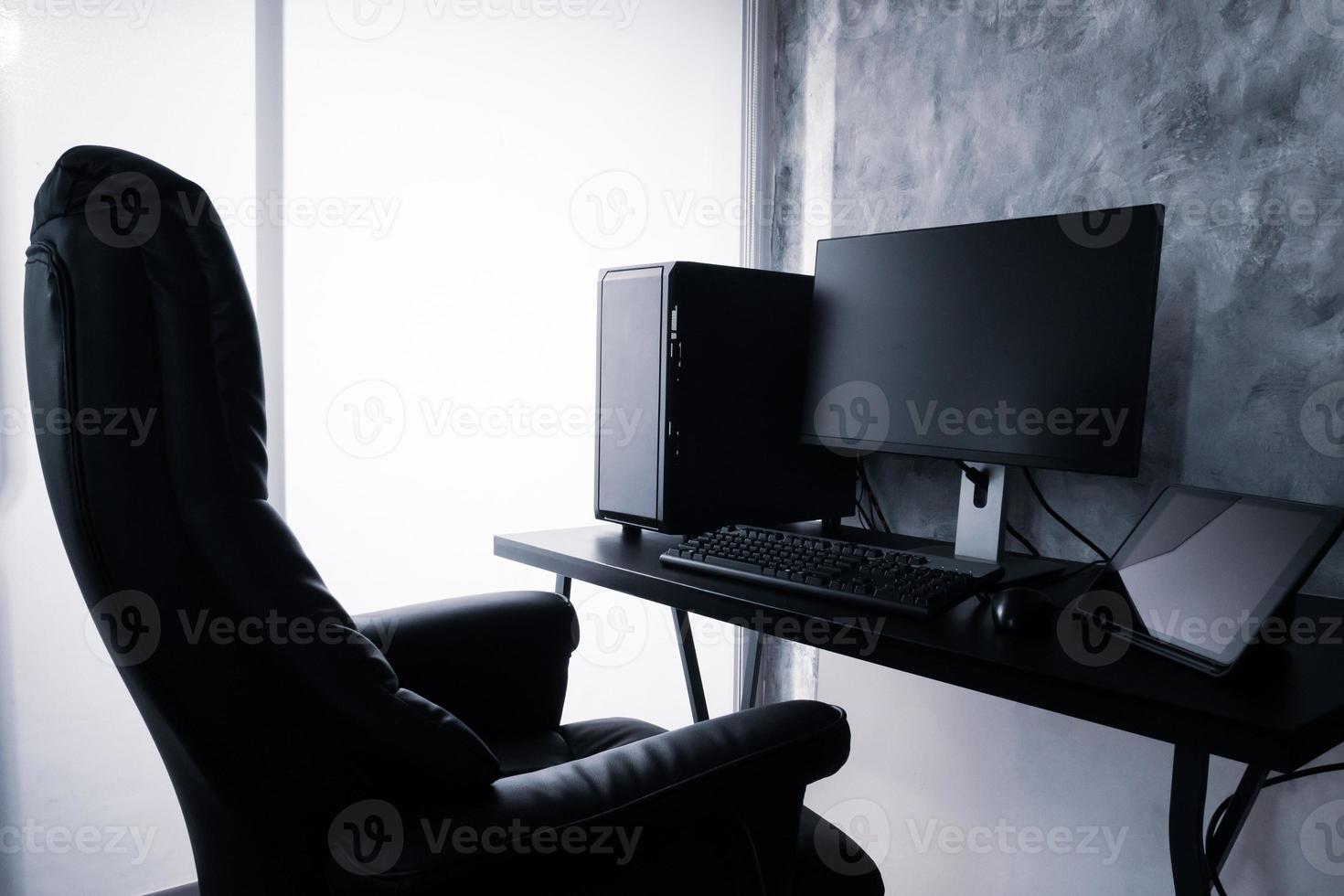 Black computer and tablet on the desk. photo