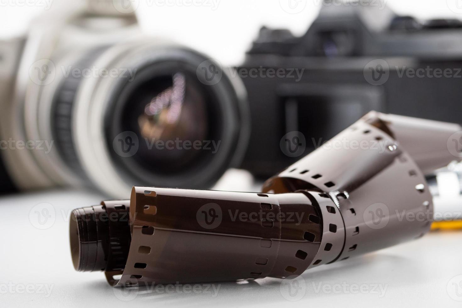 Single lens reflex cameras and a film roll on a white background. photo