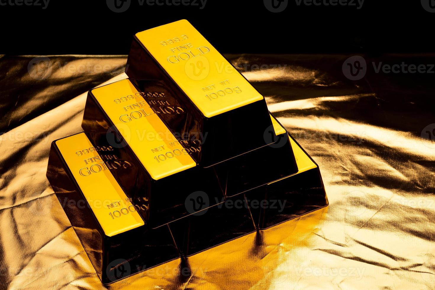 Stack of gold bars on shiny yellow background. photo