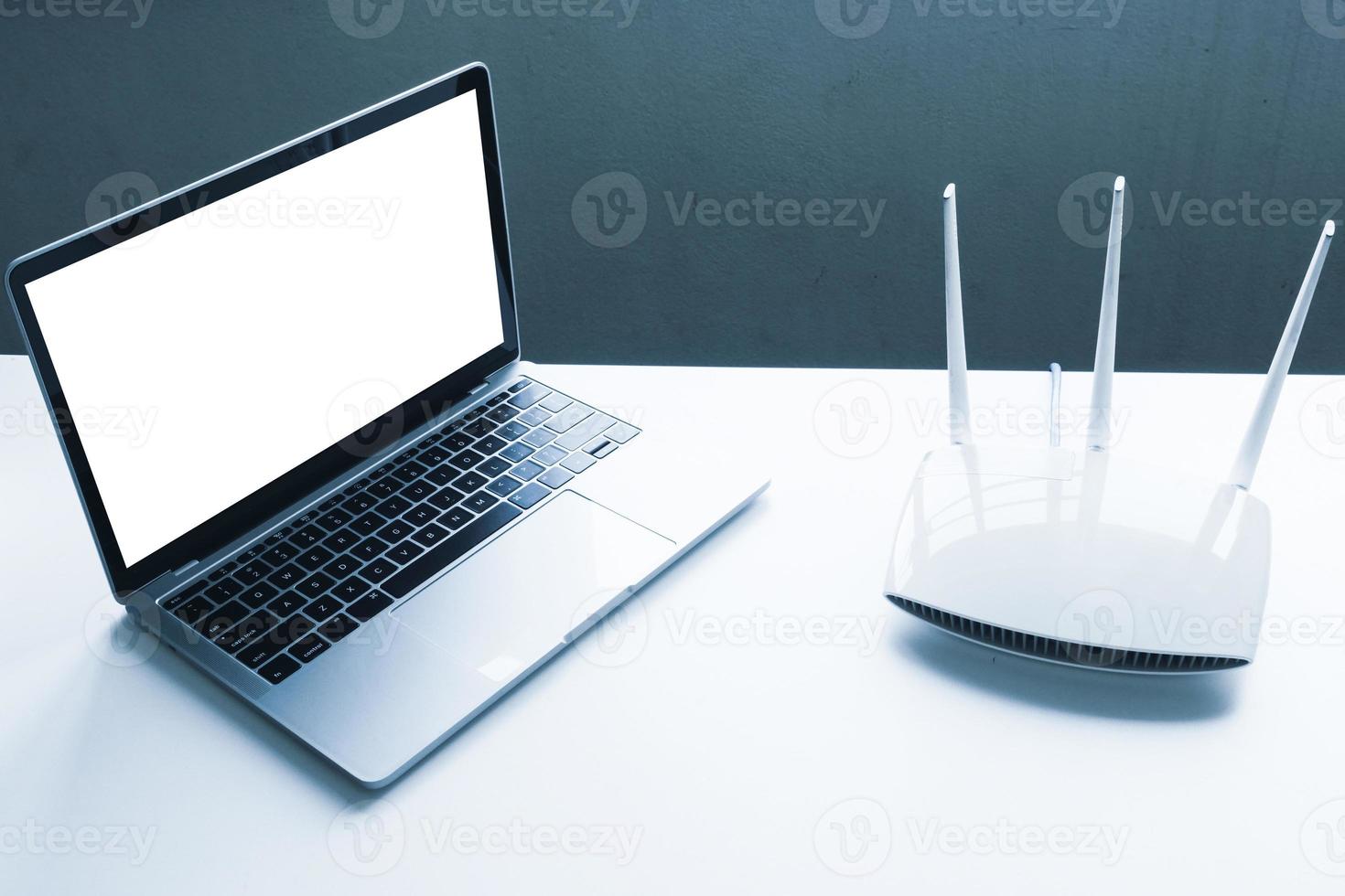 Blank screen laptop computer and router device on the table photo