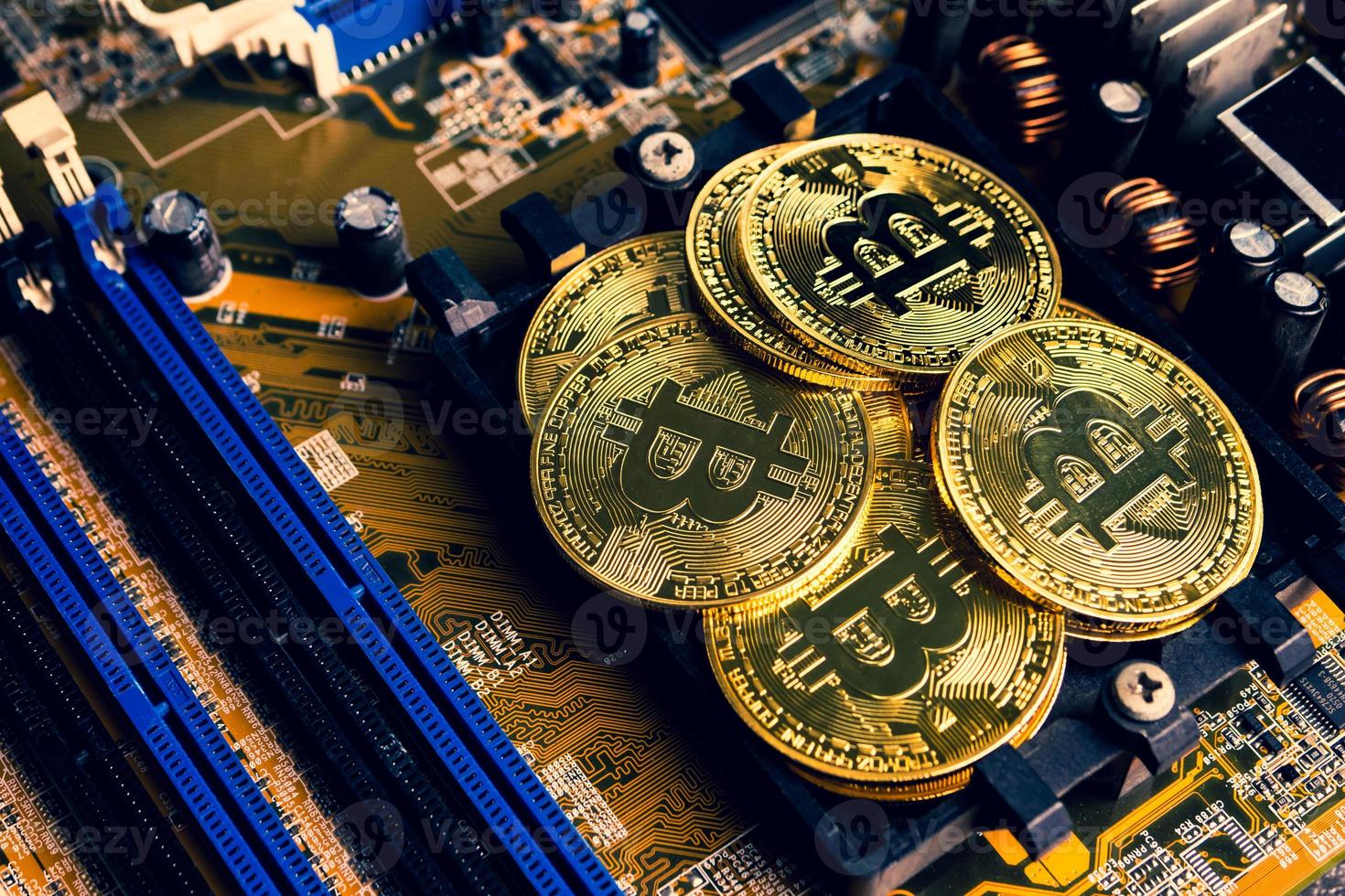 Golden coins with bitcoin symbol on a mainboard. photo