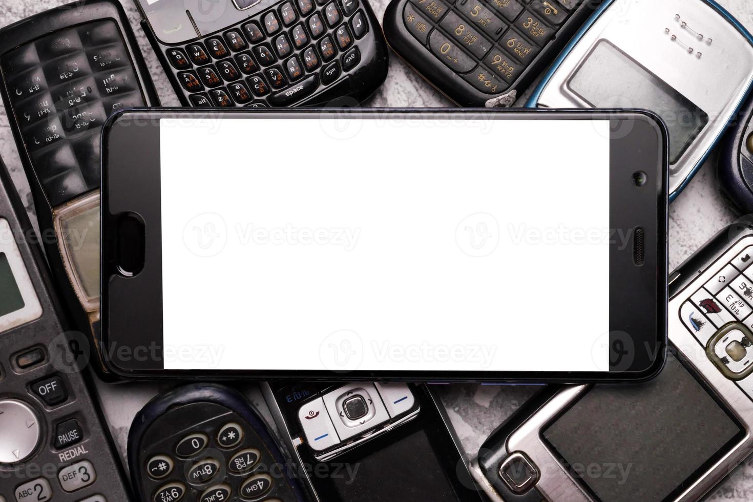 un teléfono inteligente en un montón de teléfonos celulares obsoletos. foto