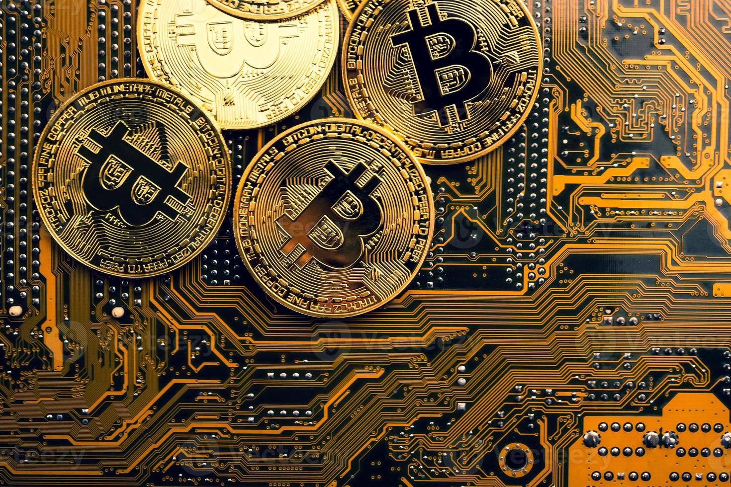Golden coins with bitcoin symbol on a mainboard. photo
