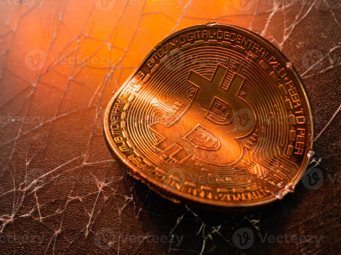 Twisted gold coin with bitcoin symbol. Concept of a cryptocurrency market crisis. photo