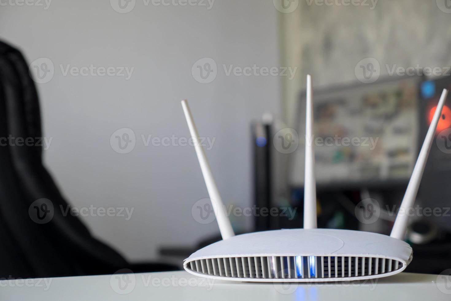 Close up of a wireless router on table at home with desktop computer background photo