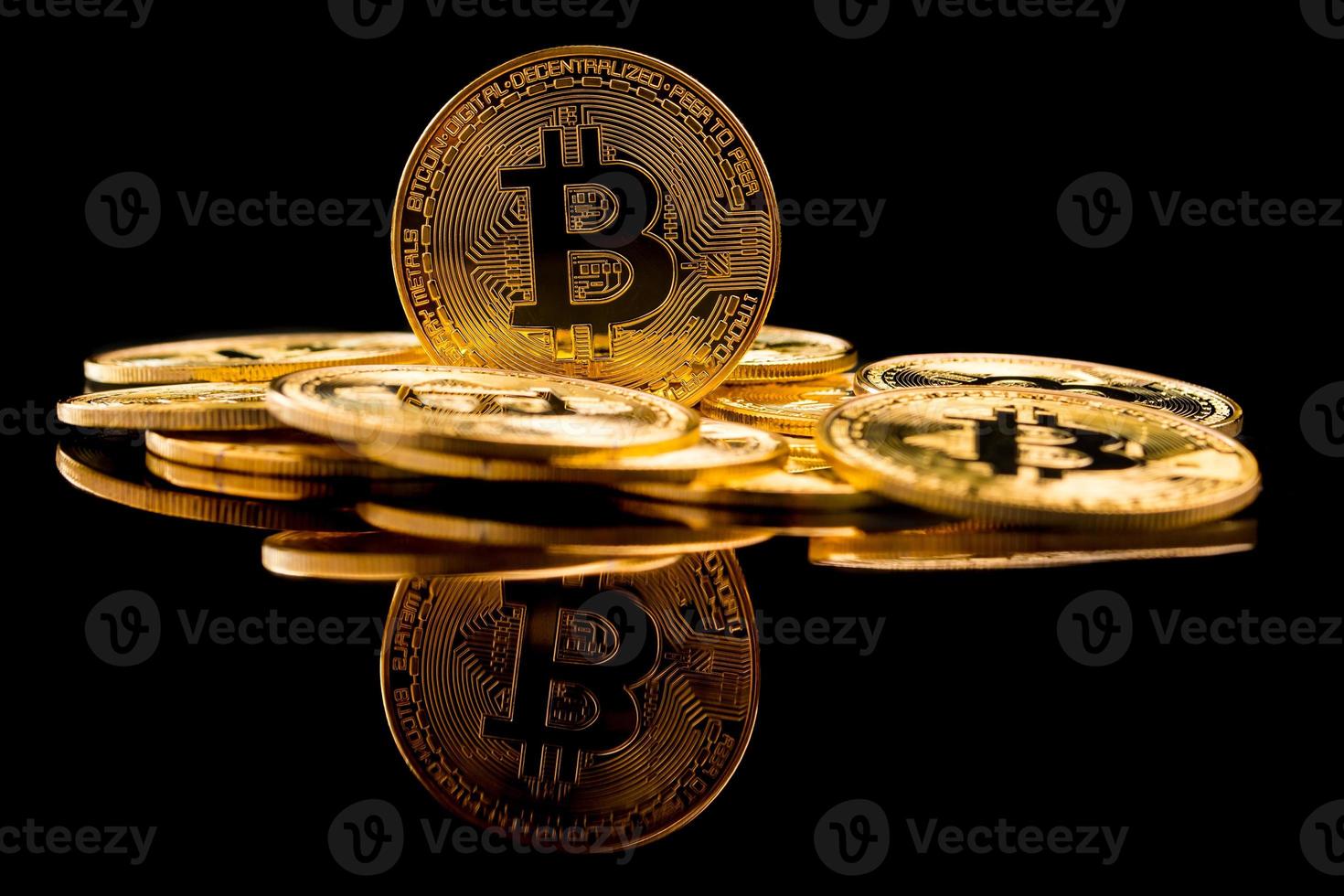 Golden coins with bitcoin symbol on a black background. photo