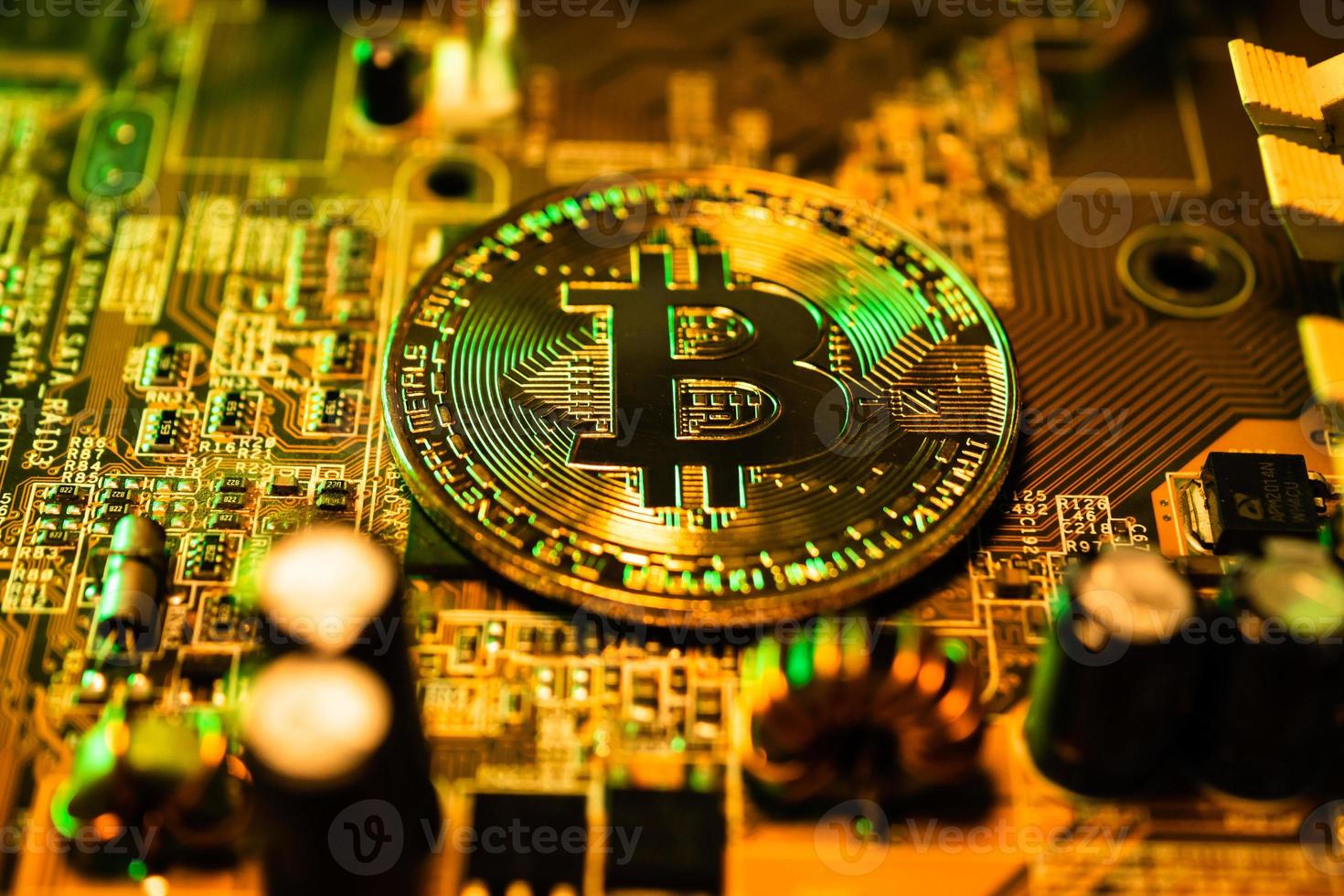 Golden coins with bitcoin symbol on a main board computer. photo