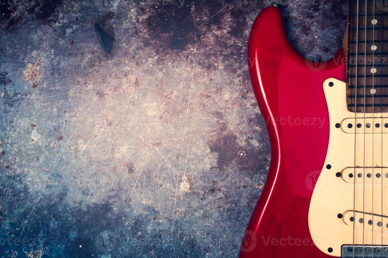 A red electric guitar on a grunge background. photo