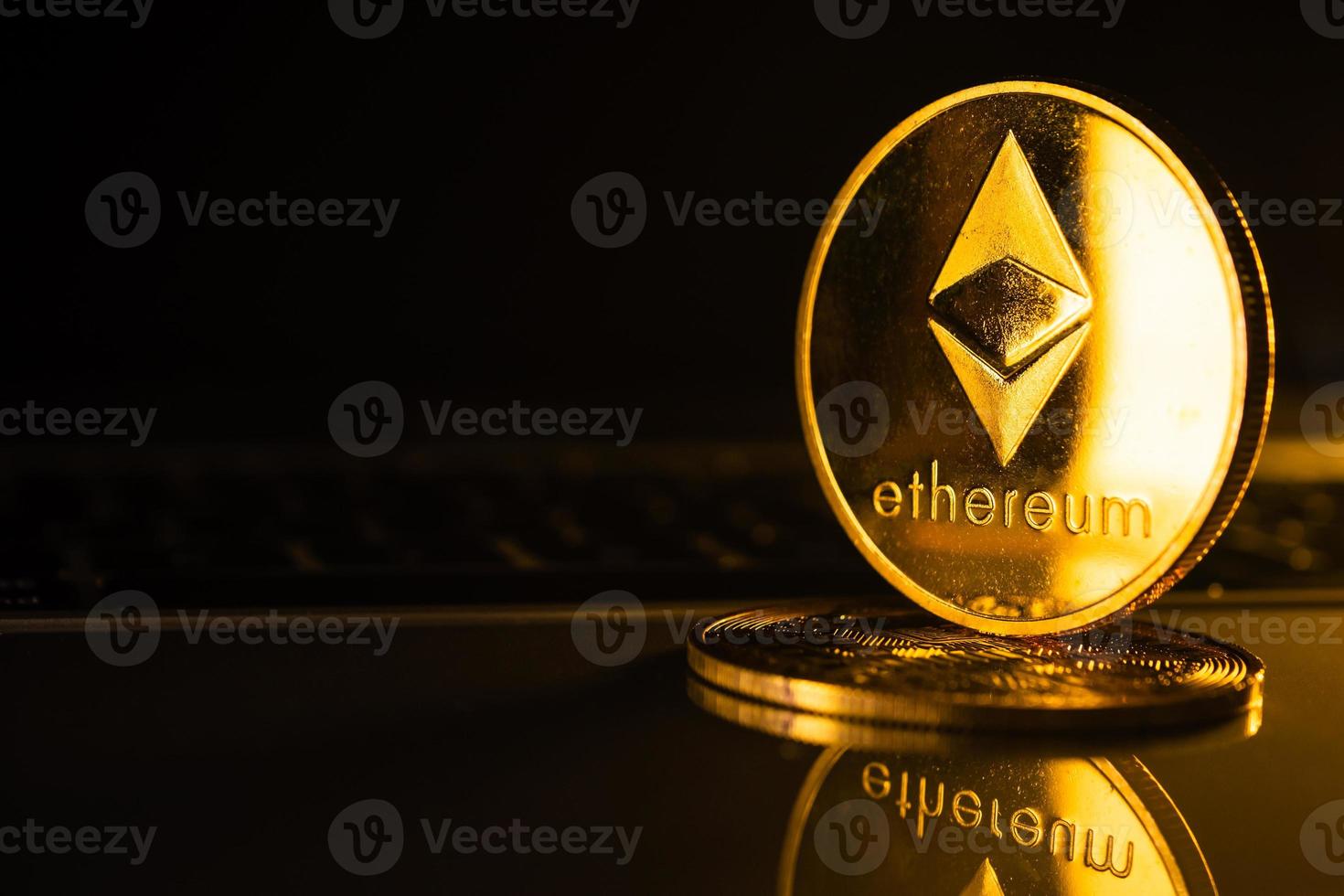 Golden coins with ethereum symbol on computer. photo