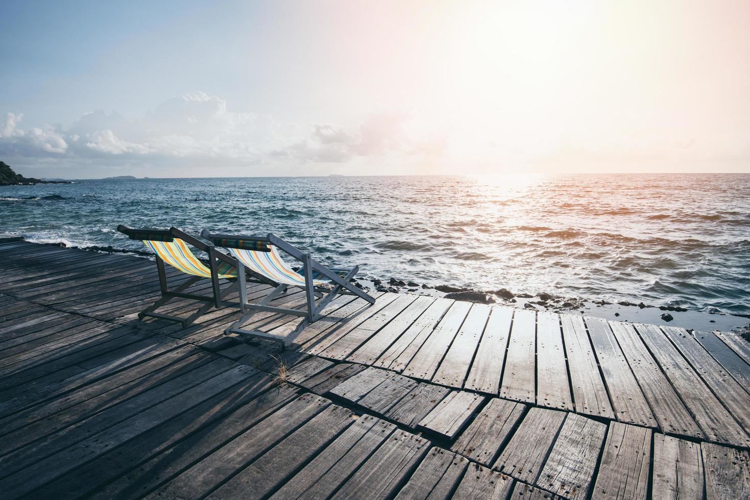 Terrace view of sea waves and coast landscape seascape rock with bench chair beach on wooden bridge balcony Tropical island with ocean blue sky and resort background in Thailand summer beach photo