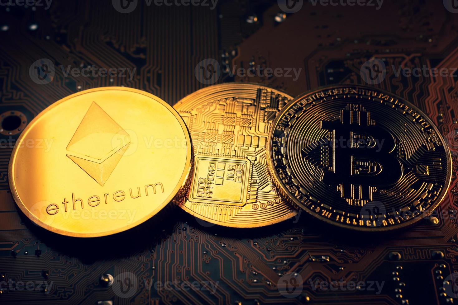 Golden coins with ethereum and bitcoin symbol on a mainboard. photo