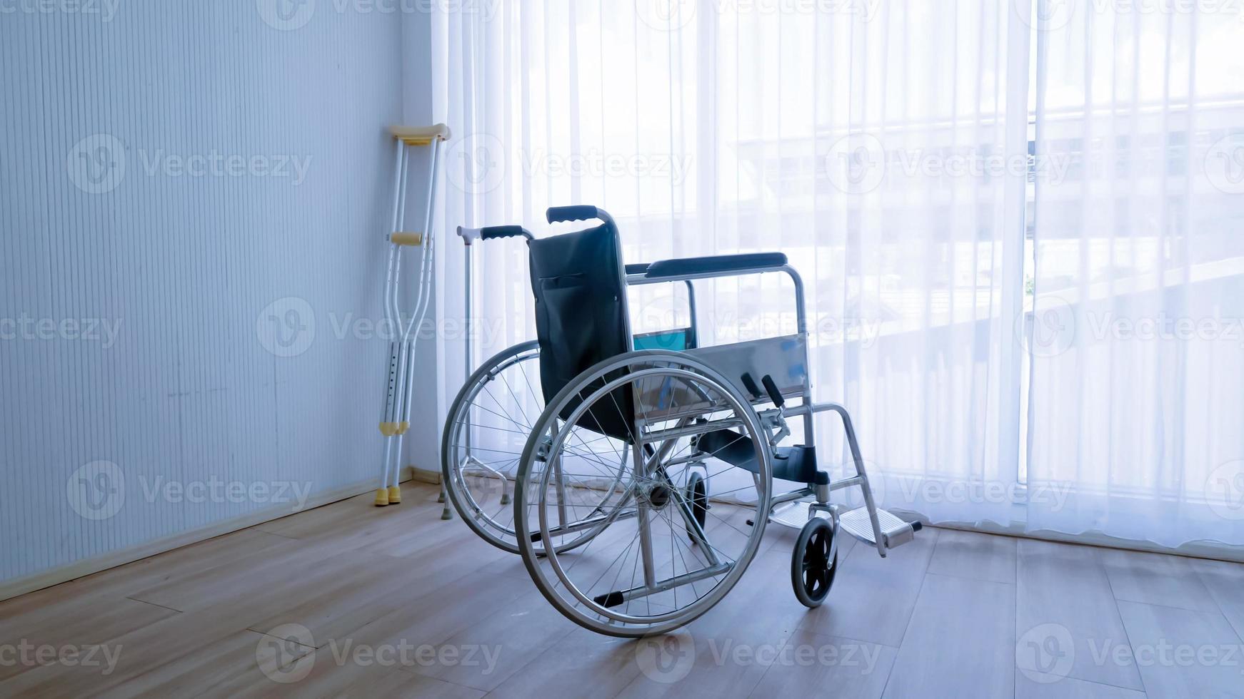 Empty modern wheelchair and walking stick or canes in hospital room. photo