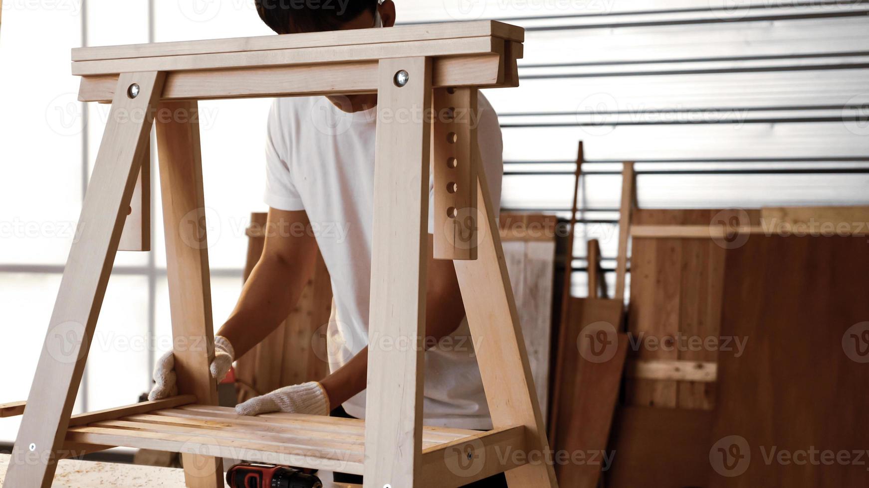 Carpenter fitting pieces of boards together at site. photo