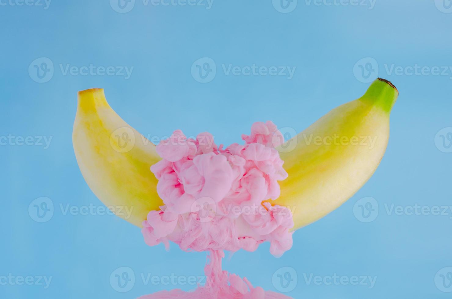 A banana fruit with partial focus of dissolving pink poster color photo