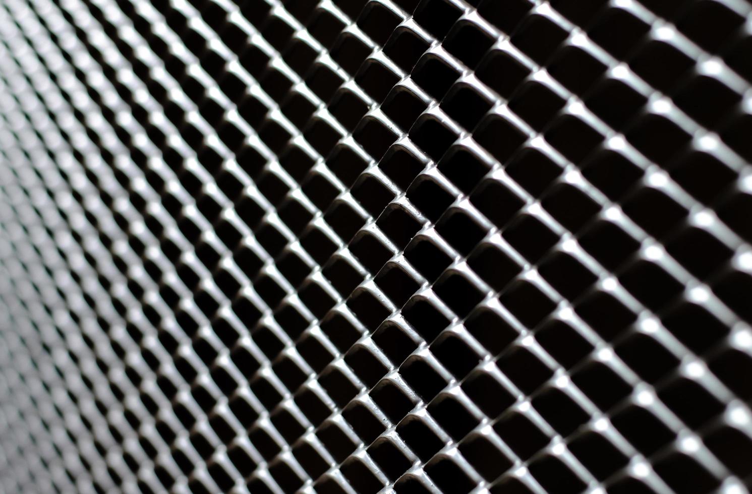 Focus and blurred of dark gray and silver grid of metal fence that taking as background. photo