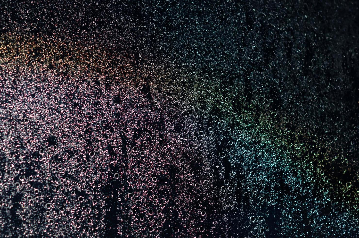 Focus and blurred photo of Rain drop on glass window with dark blue color and light reflection on it for abstract and background concept.