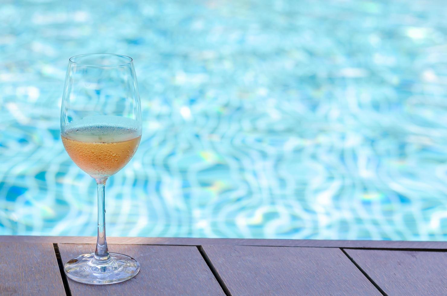 A glasses of Rose wine put on swimming pool. photo