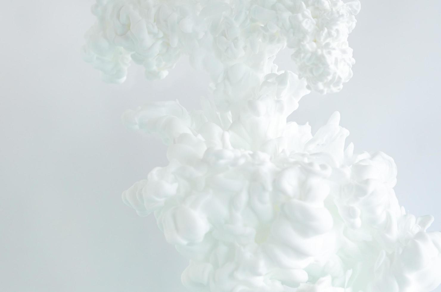 Blurred and focus white poster color dissolving in water for abstract and backgorund concept. photo
