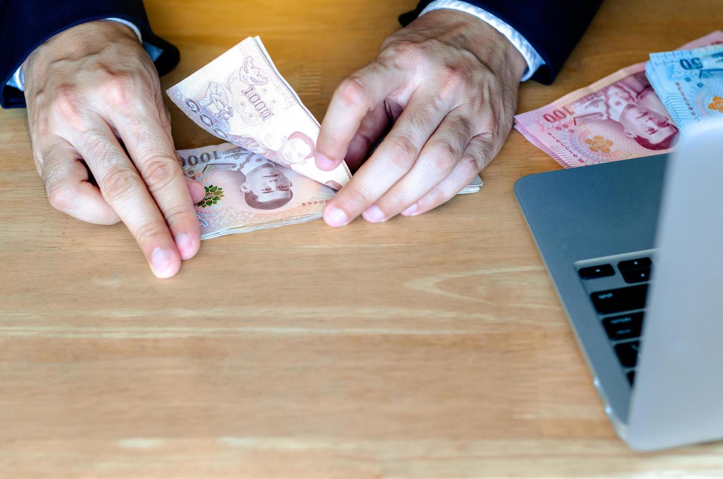 The man hand counting Thai baht banknote. photo