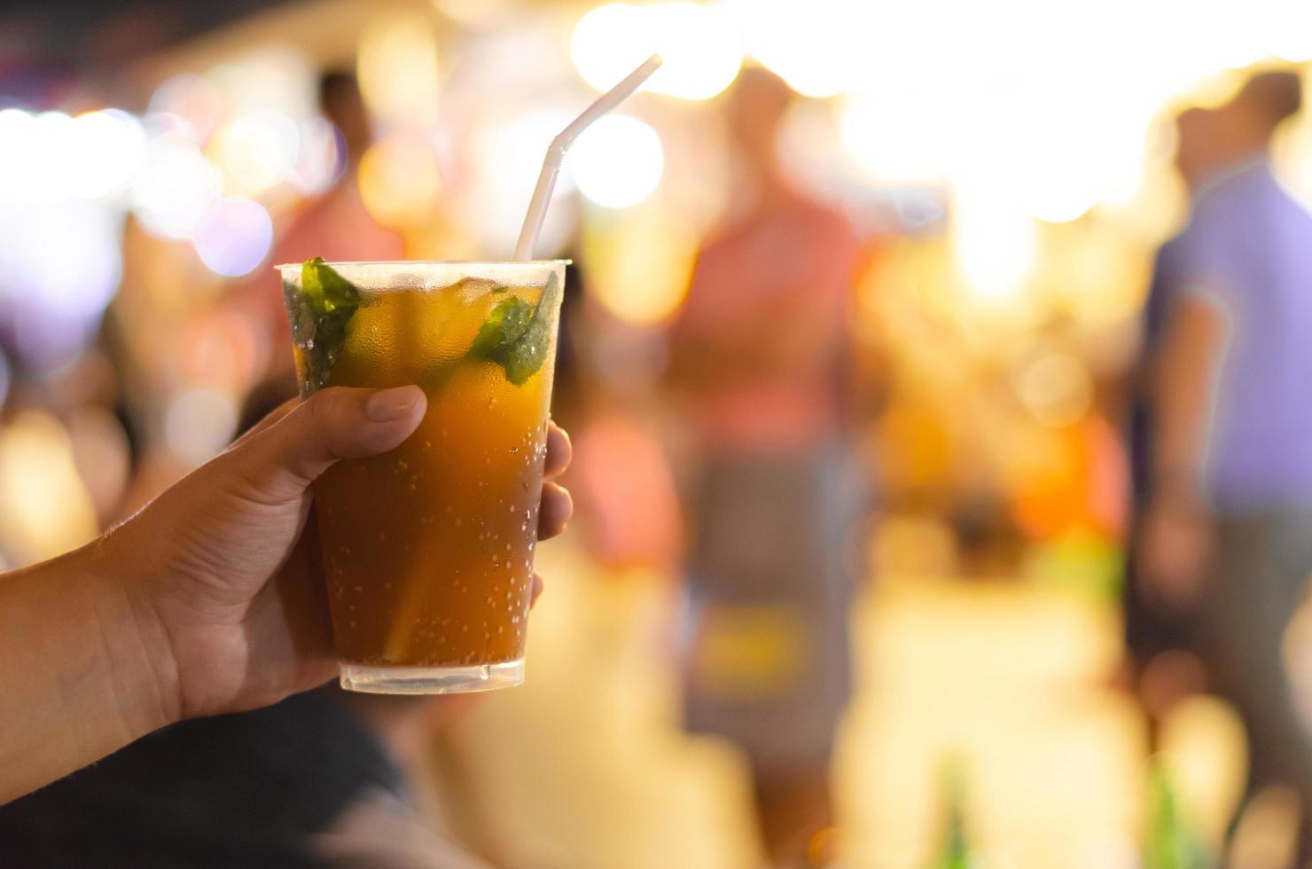 mano sosteniendo un vaso de mojito con hoja de menta. foto