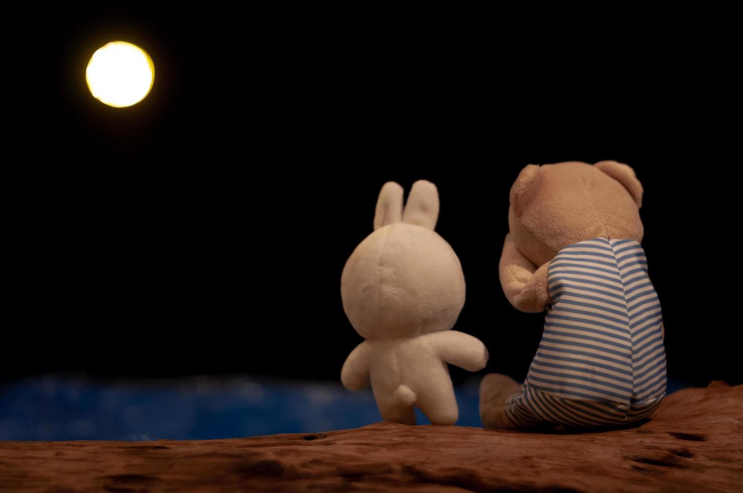 Teddy bear crying and rabbit doll giving consolation. photo