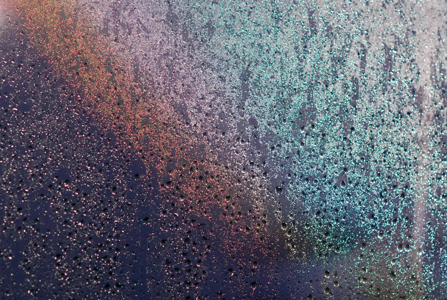 Focus and blurred photo of Rain drop on glass window with dark blue color and light reflection on it for abstract and background concept.