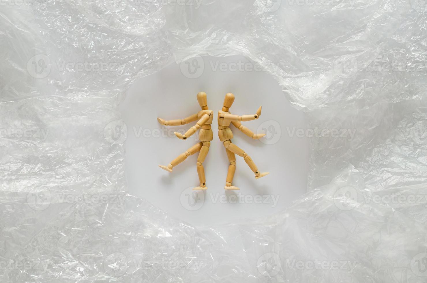 Two wooden models surrounding with many plastic bags. Stop using plastic bag for world environment day concept. photo
