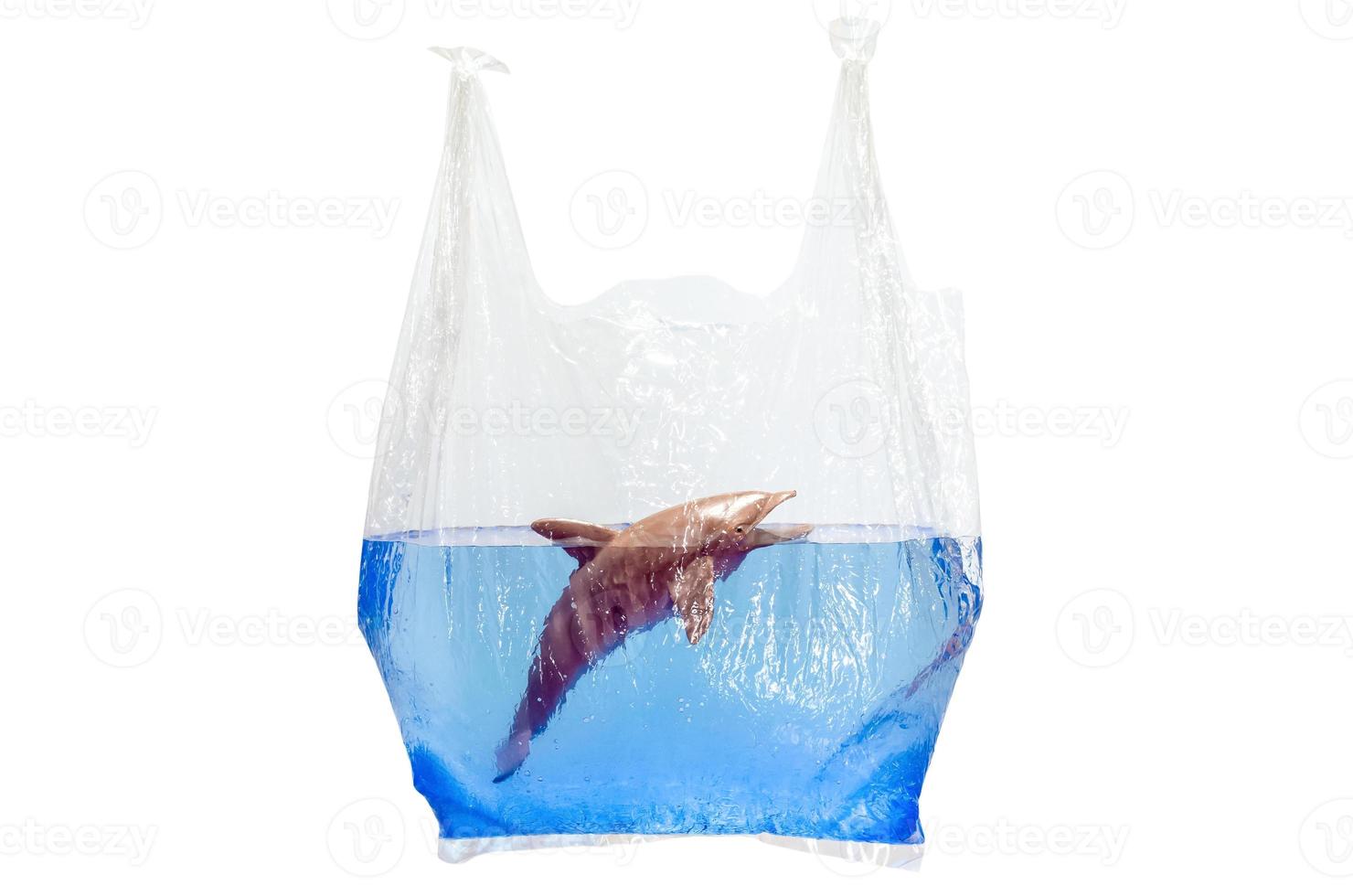 Plastic bag holding blurred dolphin toy model in water surface isolated on white background. Minimal world ocean day concept. photo