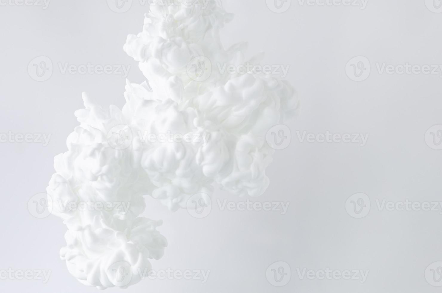 Blurred and focus white poster color dissolving in water for abstract and backgorund concept. photo