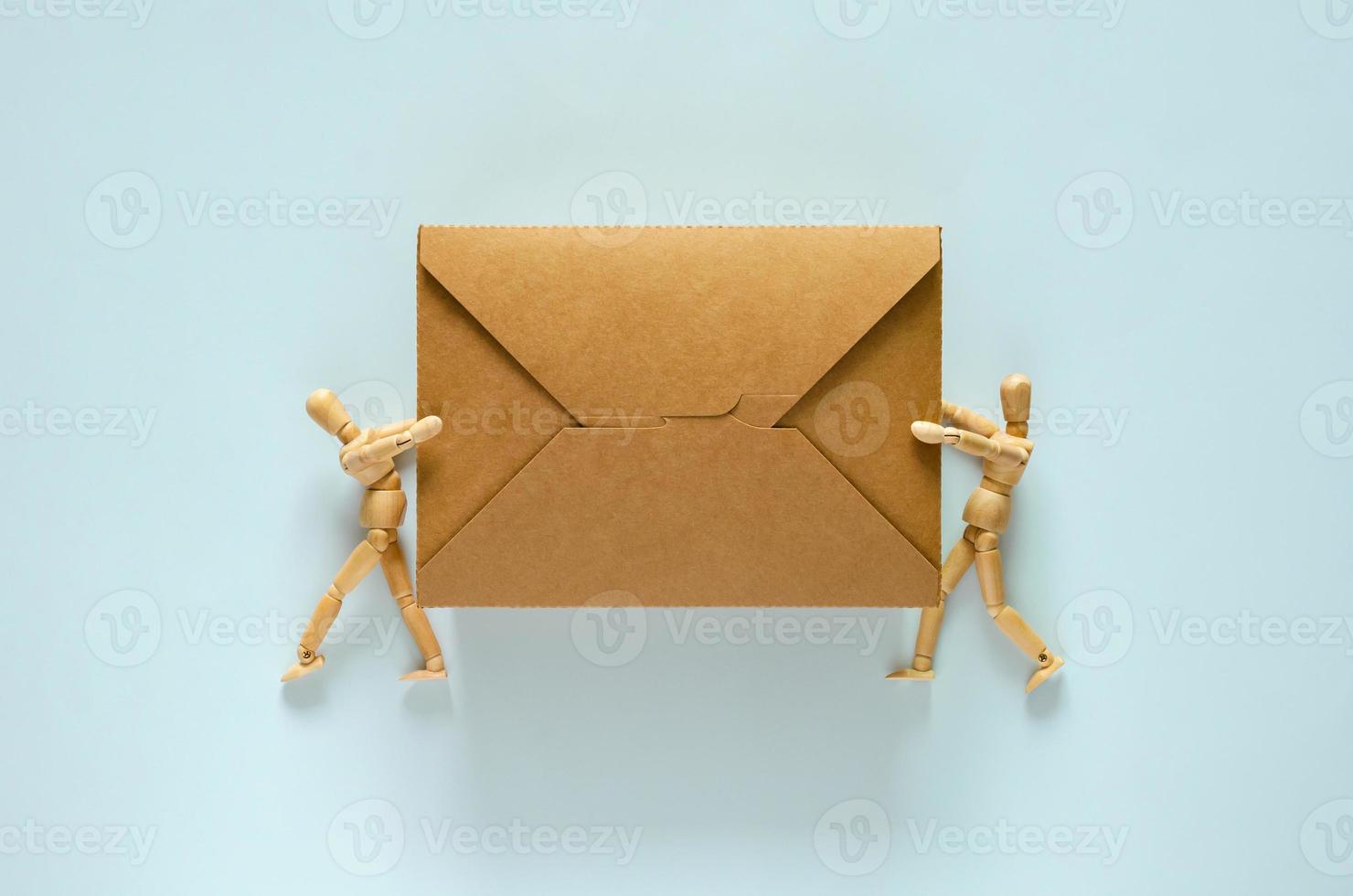 Two wooden models holding disposable, compostable paper food box for world environment day concept. photo