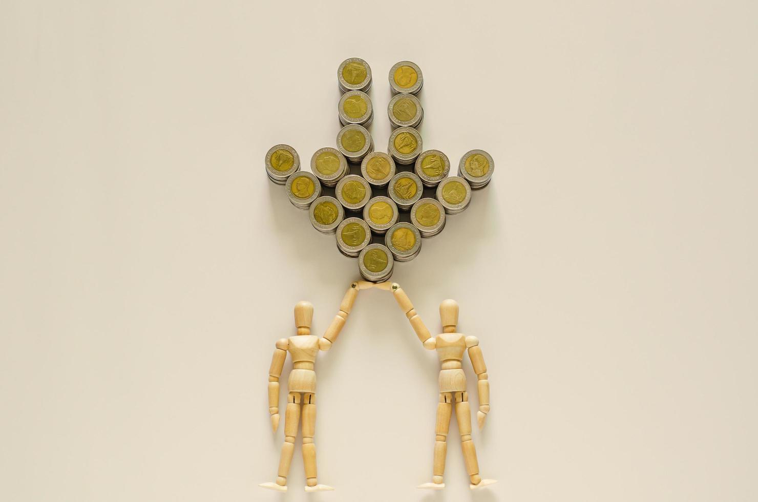 Two wood models carrying Thai baht coins that set as down arrow. photo