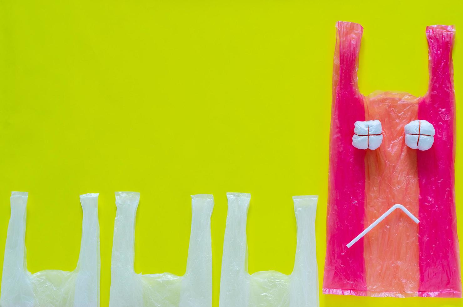 Pink plastic set as unhappy expression face with plastic straw for stop using unfriendly environmental packages. photo