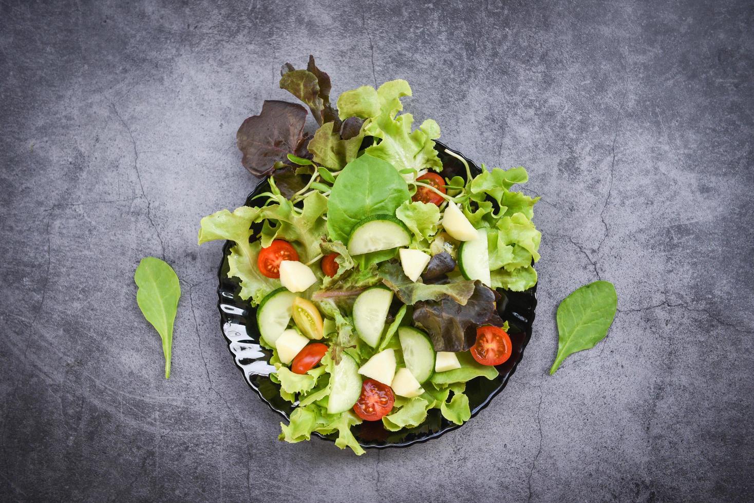Healthy salad vegetable leaves mix salad with fruit and fresh lettuce tomato cucumber on plate on table fresh food eating photo