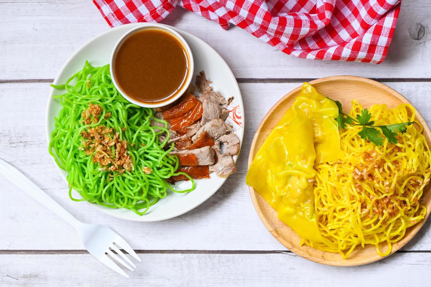 Jade noodle and yellow noodles Asian Thailand food , roasted duck with jade noodle and pork dumplings on plate and duck sauce , green noodles Chinese food photo