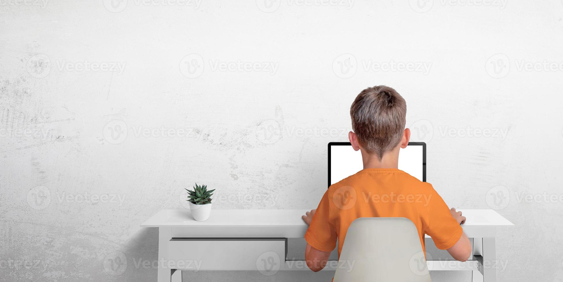 Boy typing on a laptop computer. The concept of sending an email or corresponding with friends. Protection of privacy of minors photo