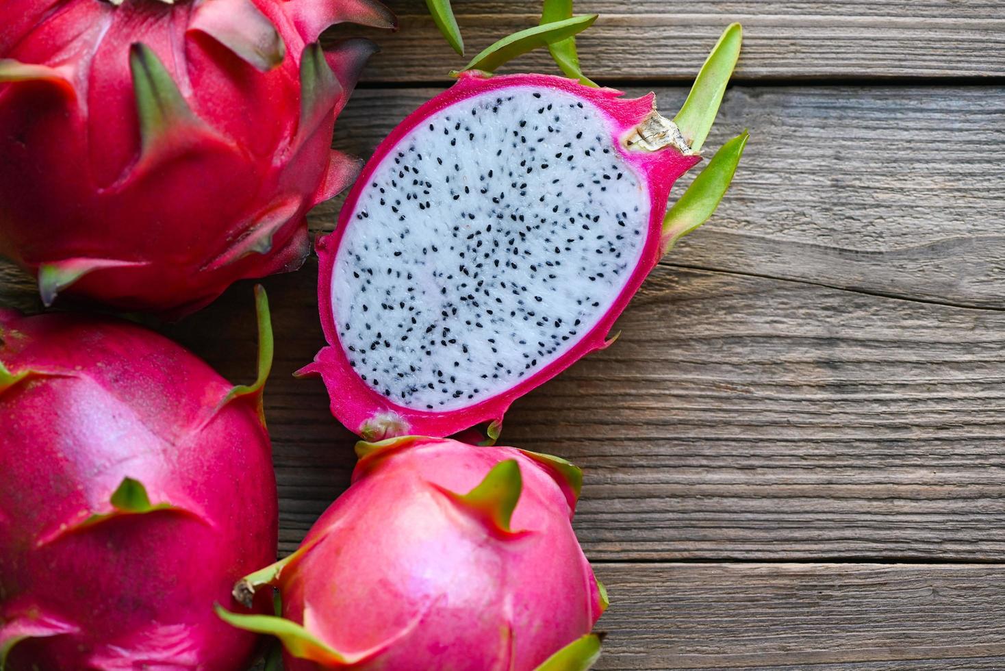 fruta de dragón fresca tropical en el concepto de fruta saludable de tailandia asiática, fruta de dragón cortada a la mitad en madera con fondo de pitahaya foto