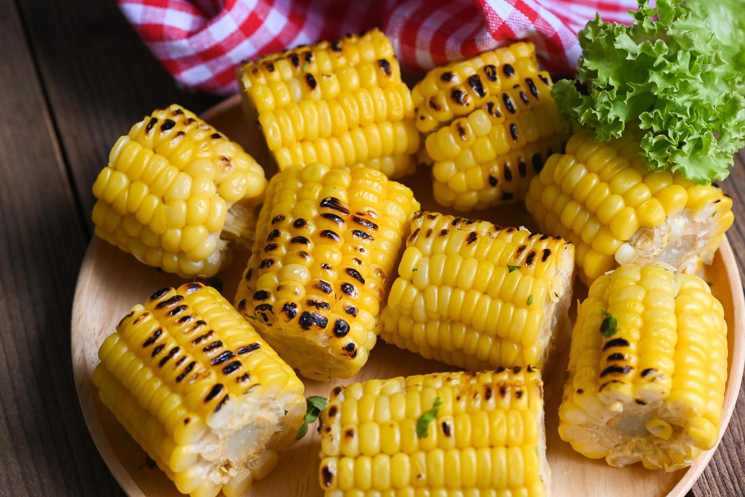 sweet corn cooked on plate background, sweet corn food with salad vegetable lettuce, ripe corn cobs grilled sweetcorn for food vegan dinner or snack photo