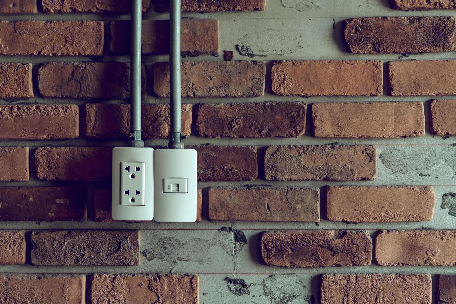 Power plug on brick wall, vintage background with copy space photo
